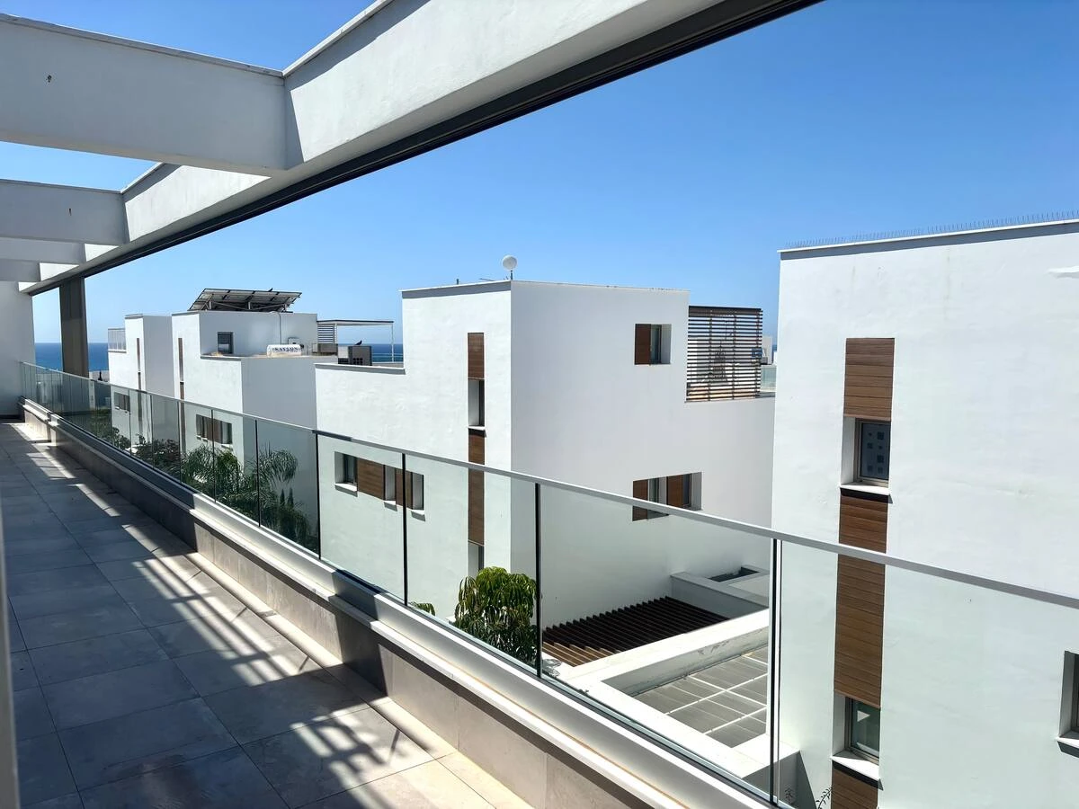 Dachterrasse mit Glasgeländer und Blick aufs Meer